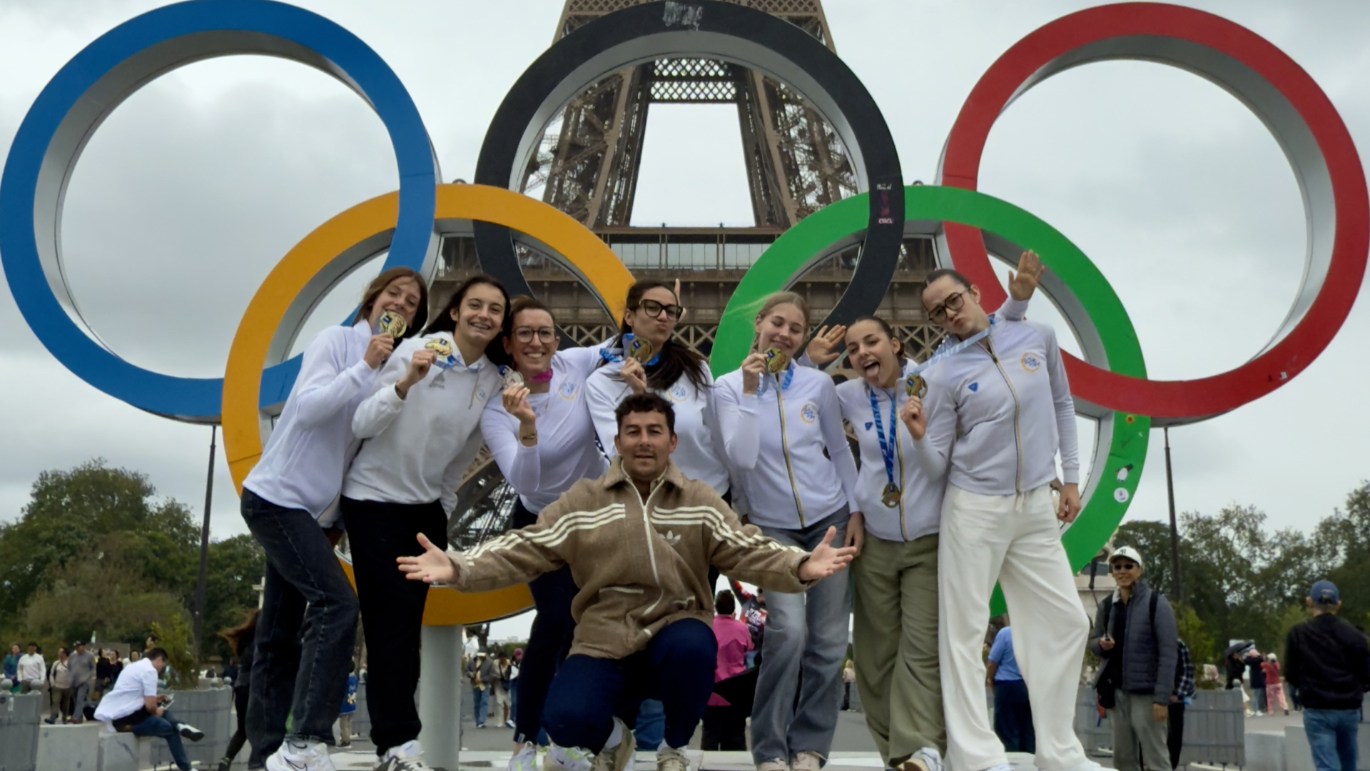 Rémi Laâsri avec les gymnastes de l’ISM Montluçon devant les anneaux olympiques et la tour Eiffel à Paris